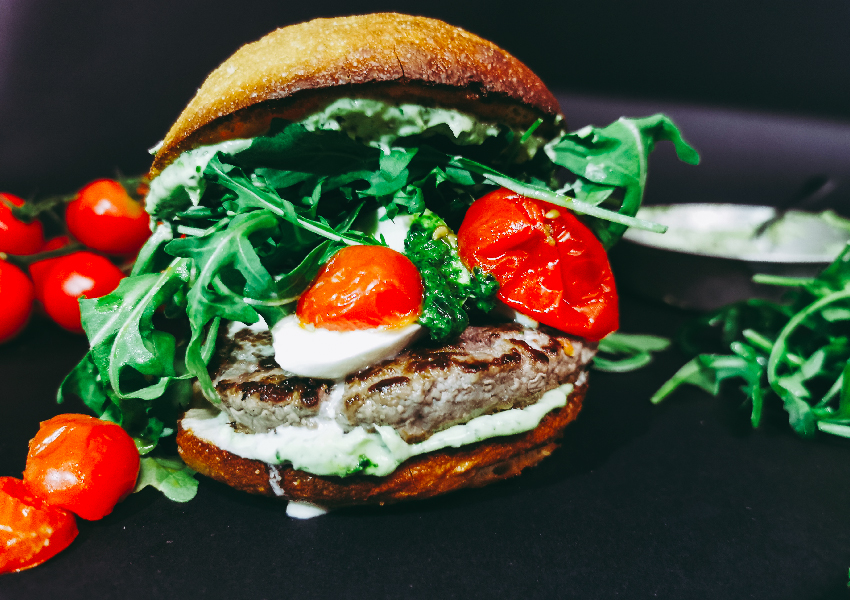 Foto frontale in primissimo piano di ITALO: un hamburger senza glutine con rucola, mozzarella e pomodori confit da ordinare a domicilio